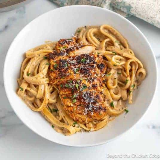 Blackened Chicken Alfredo in a white bowl.