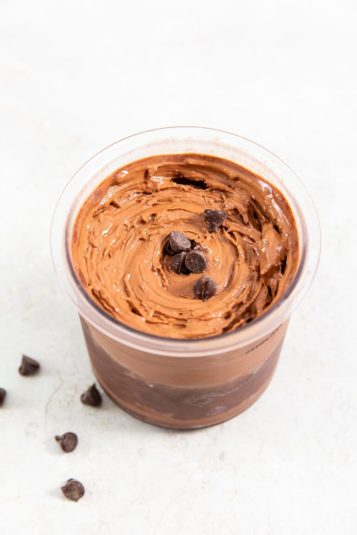 Chocolate Protein Ice Cream Nija CREAMi with chocolate chips in a glass jar.