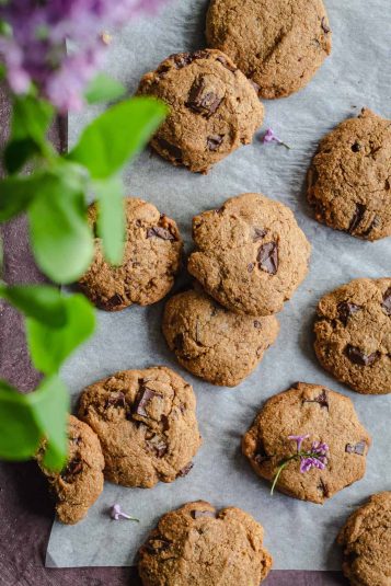 Cinnamon cookies spread on a sheet with flours above.