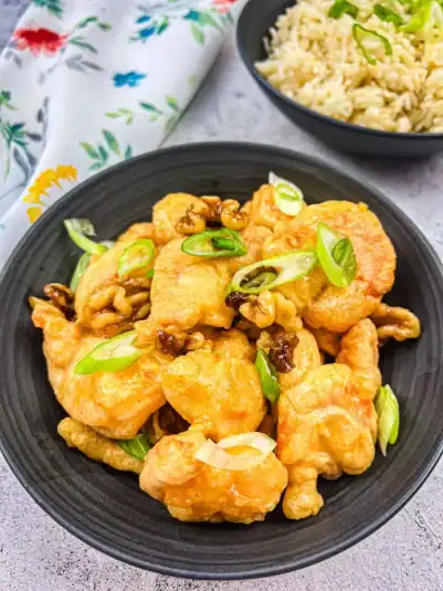 A plate of cottage cheese toast with blueberries, next to a honey dipper.