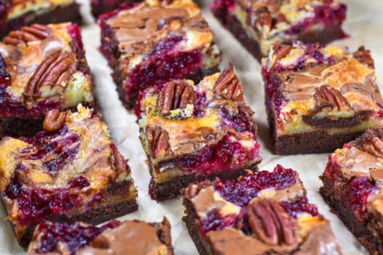 Brie and cranberry brownies on a sheet of parchment.