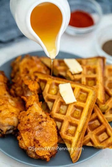 Pouring syrup over Fried Chicken and Waffles.