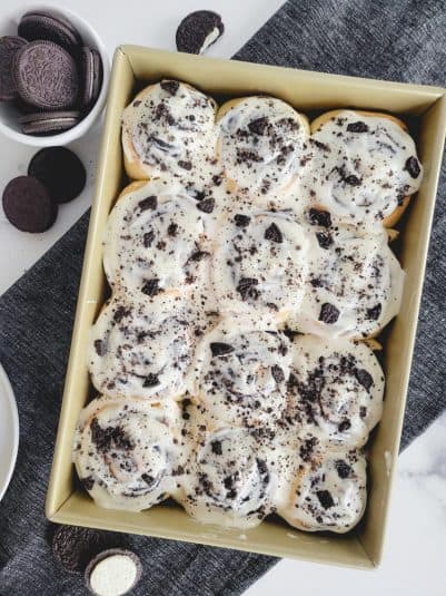 Oreo Cinnamon Rolls with cream cheese frosting in a 9x13 inch pan.