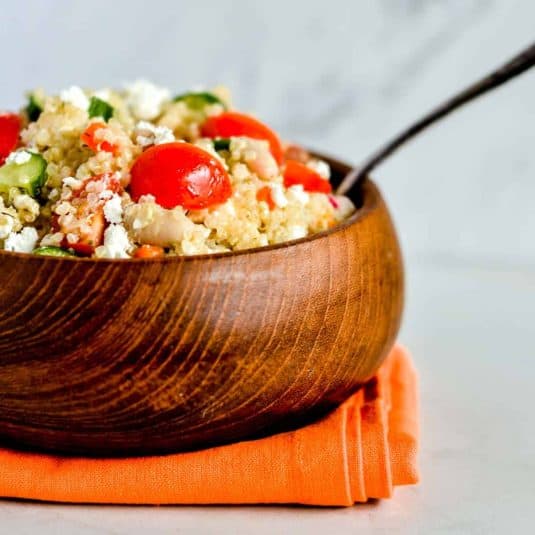 A stack of three peach crumble bars on a black plate.
