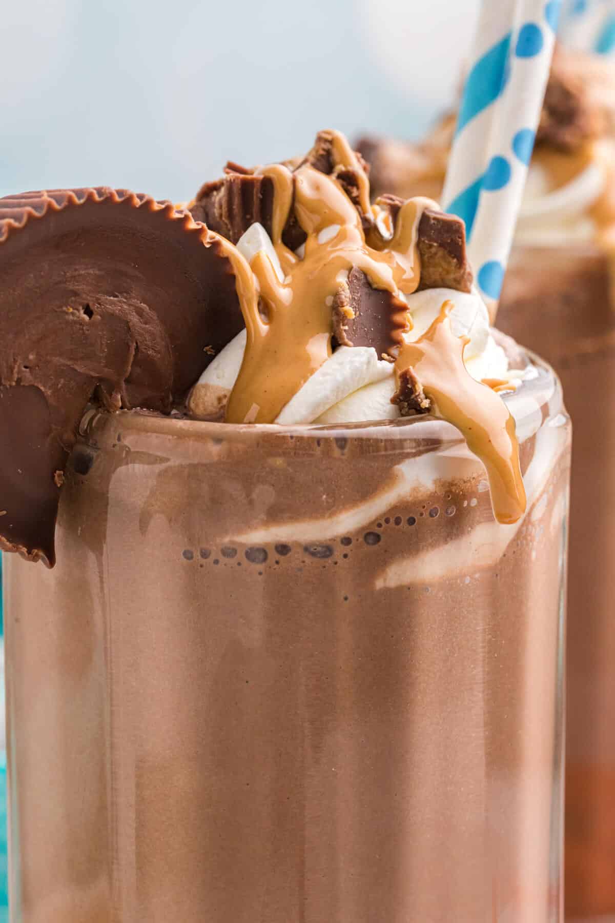 Chocolate milkshake topped with peanut butter and chocolate drizzle.