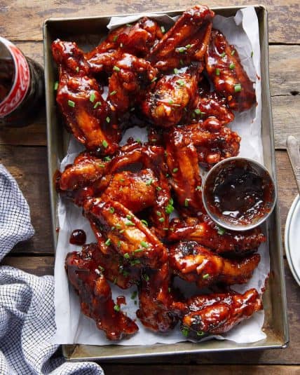 Overhead image of sticky bbq chicken wings with garnish.