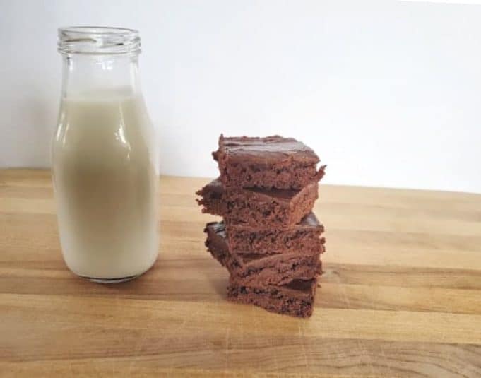 Image shows a Chocolate Marshmallow Cookie being pulled apart on a wooden table.