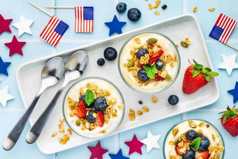 Top angle shot of a summer berries ricotta parfait with strawberries, blueberries, and mint.
