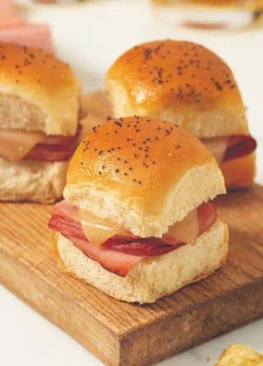 Ham and Cheese Sliders on a wooden board.