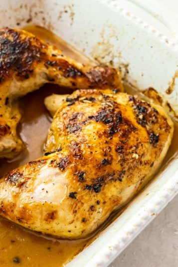 Easy Broiled Chicken Leg Quarters in a white casserole dish.