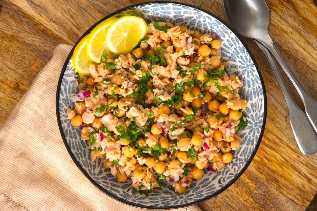 Chickpea and salmon salad with lemon slices and a spoon.