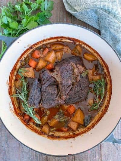 Dutch Oven Pot Roast with a sprig of rosemary.