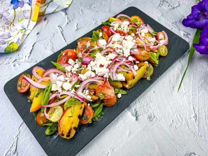 Shrimp skewers on a white plate with lemon wedges.