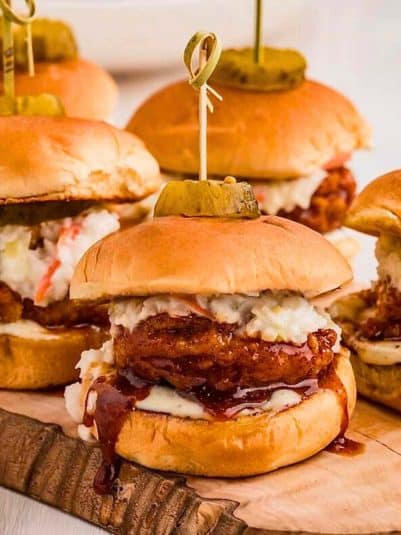 Hot honey chicken sliders on a wooden board.