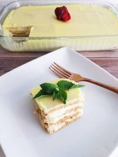 Lemon Eclair Cake on white plate with mint.