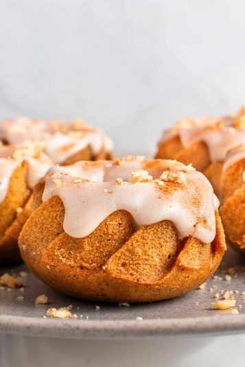 Mini pumpkin spice bundt cake with glaze on plate.