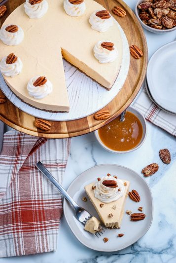 Pile of pumpkin oatmeal chocolate chip cookies with more in the background on a cooling rack.