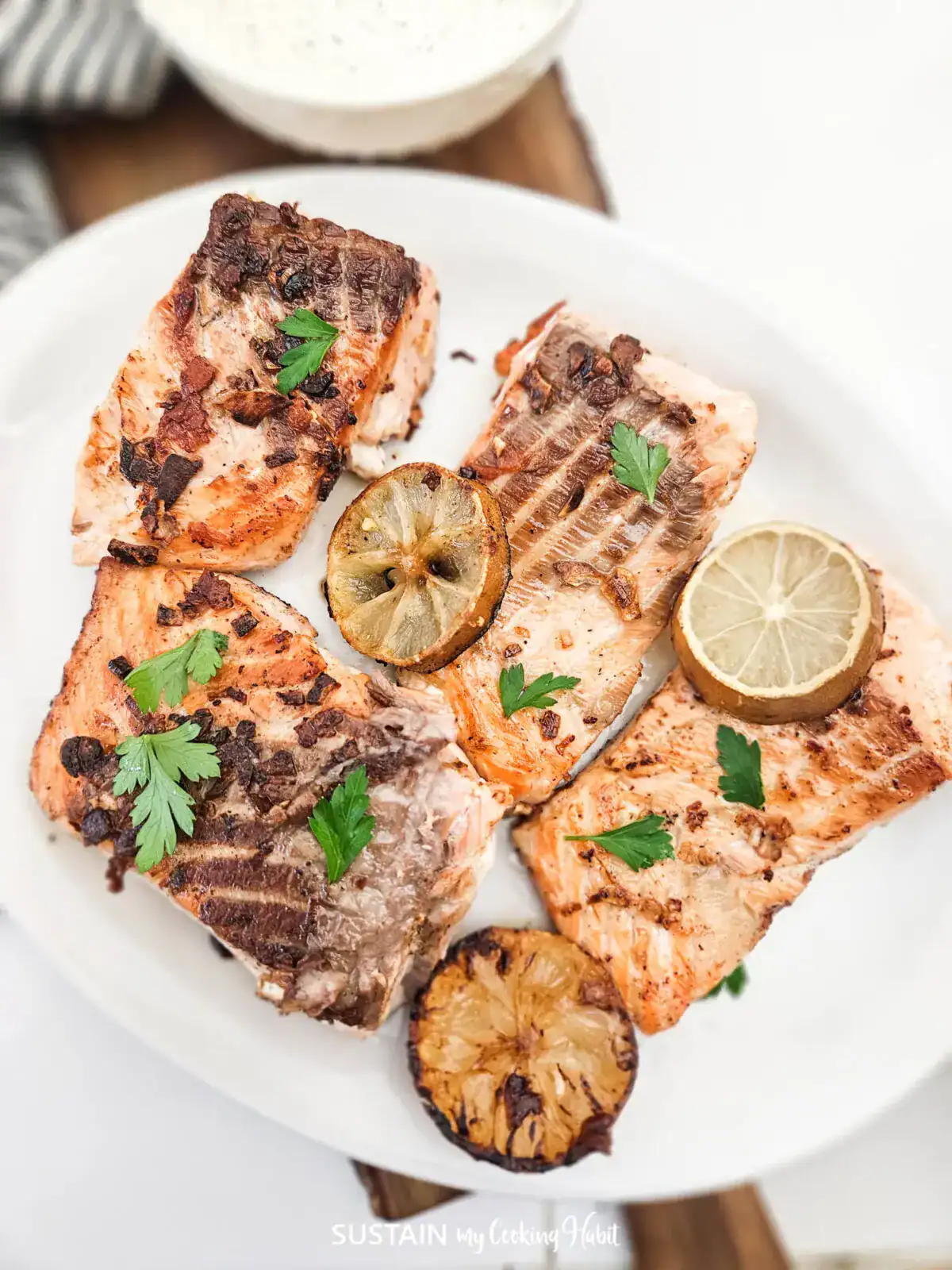 Pan seared garlic salmon on a plate with garnish.