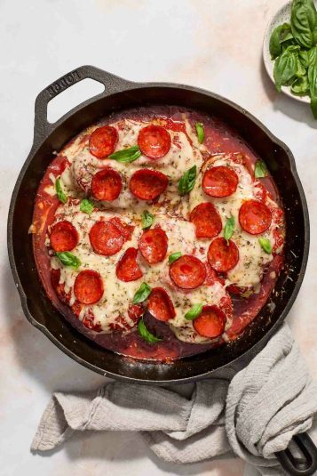 Pizza chicken in a black skillet.