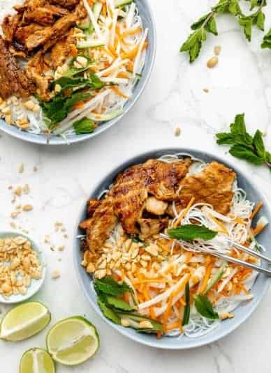 Vermicelli bowls garnished with crushed peanuts and fresh mint.