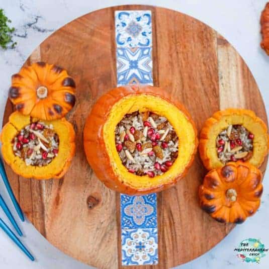 3 stuffed rice pumpkins on a wooden board.