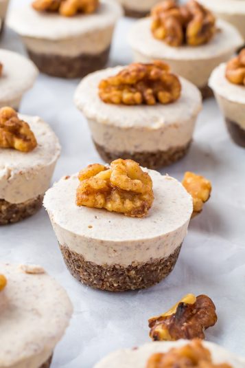 No Bake Pumpkin Cheesecake bites on parchment paper with a candied walnut on top.