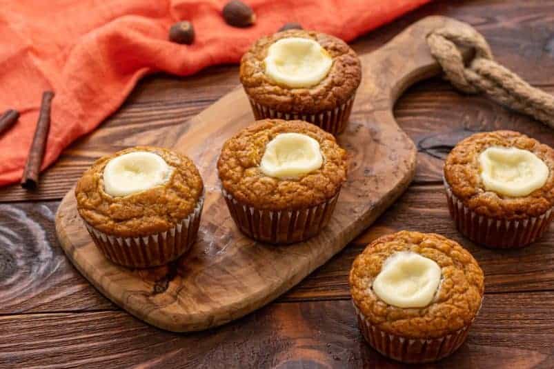 An assorted tray of pumpkin muffins with a creamy center cream cheese filling.