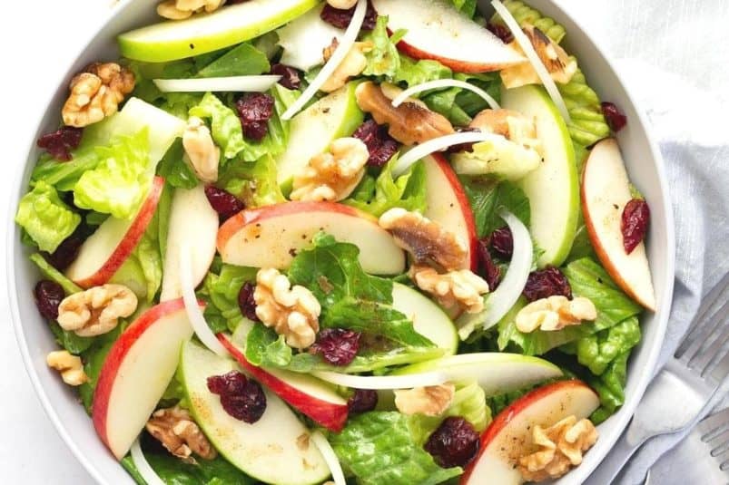 A fresh apple cranberry salad with a bright red and green color.