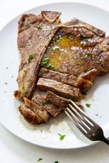 Air Fryer T-Bone Steak on a plate with pepper and parsley