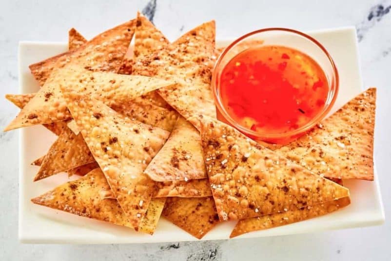 Golden wonton chips sprinkled with sesame seeds.