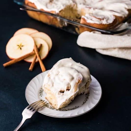 Overhead shot of a plate with three cookies next to a wire rack filled with cooling cookies.