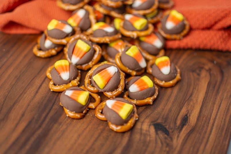 A wood board with Halloween pretzel treats on top.