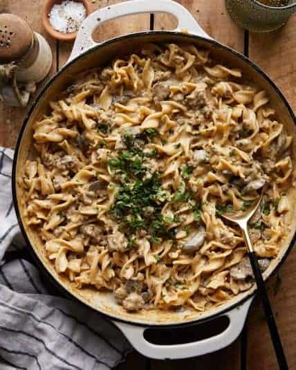 Overhead image of beef stroganoff with ground beef in a white dish with garnish.