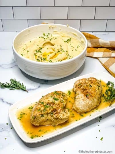 A platter or turkey tenderloin breasts and a bowl of mashed potatoes.