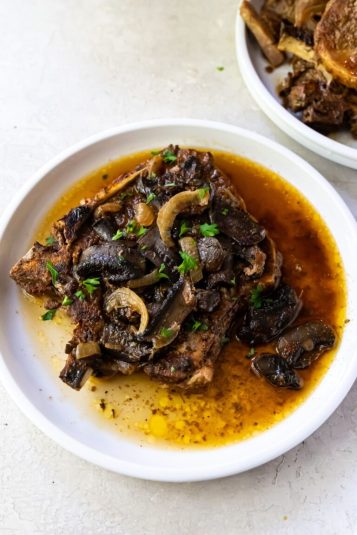 Easy Broiled Chicken Leg Quarters in a white casserole dish.