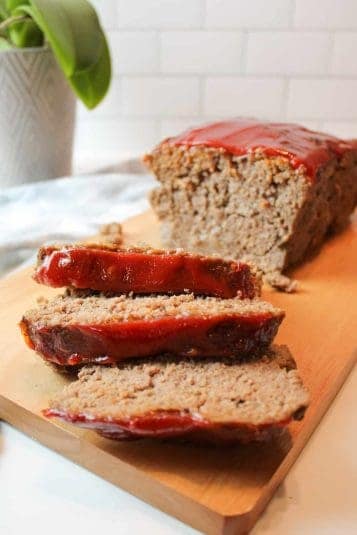Sliced meatloaf in cutting board.