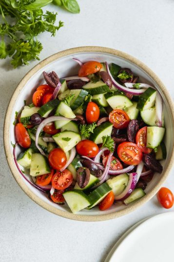 Mediterranean Cucumber Salad served in a white bowl with fresh herbs.