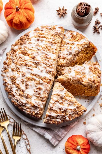 A partially sliced pumpkin coffee cake on a platter.