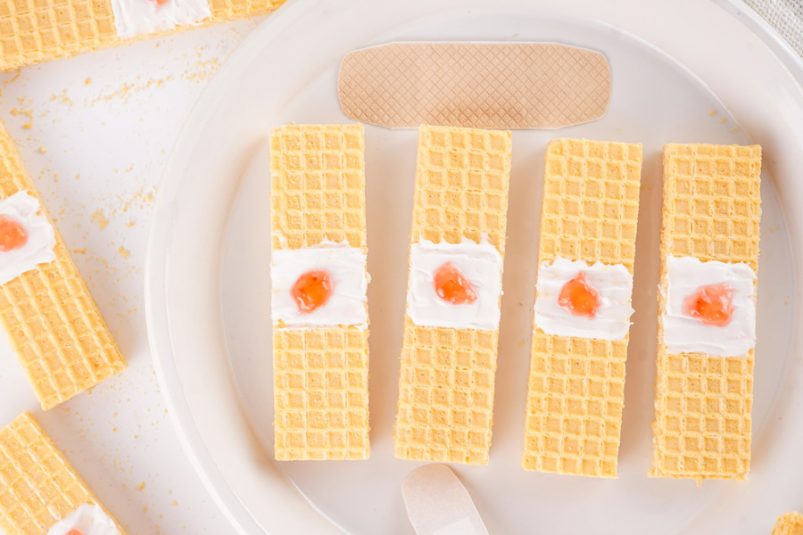 Bandaid cookies on a plate with several more around.