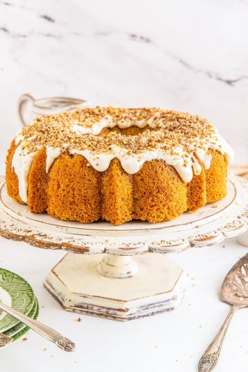 Carrot bundt cake on a ivory wooden cake stand.