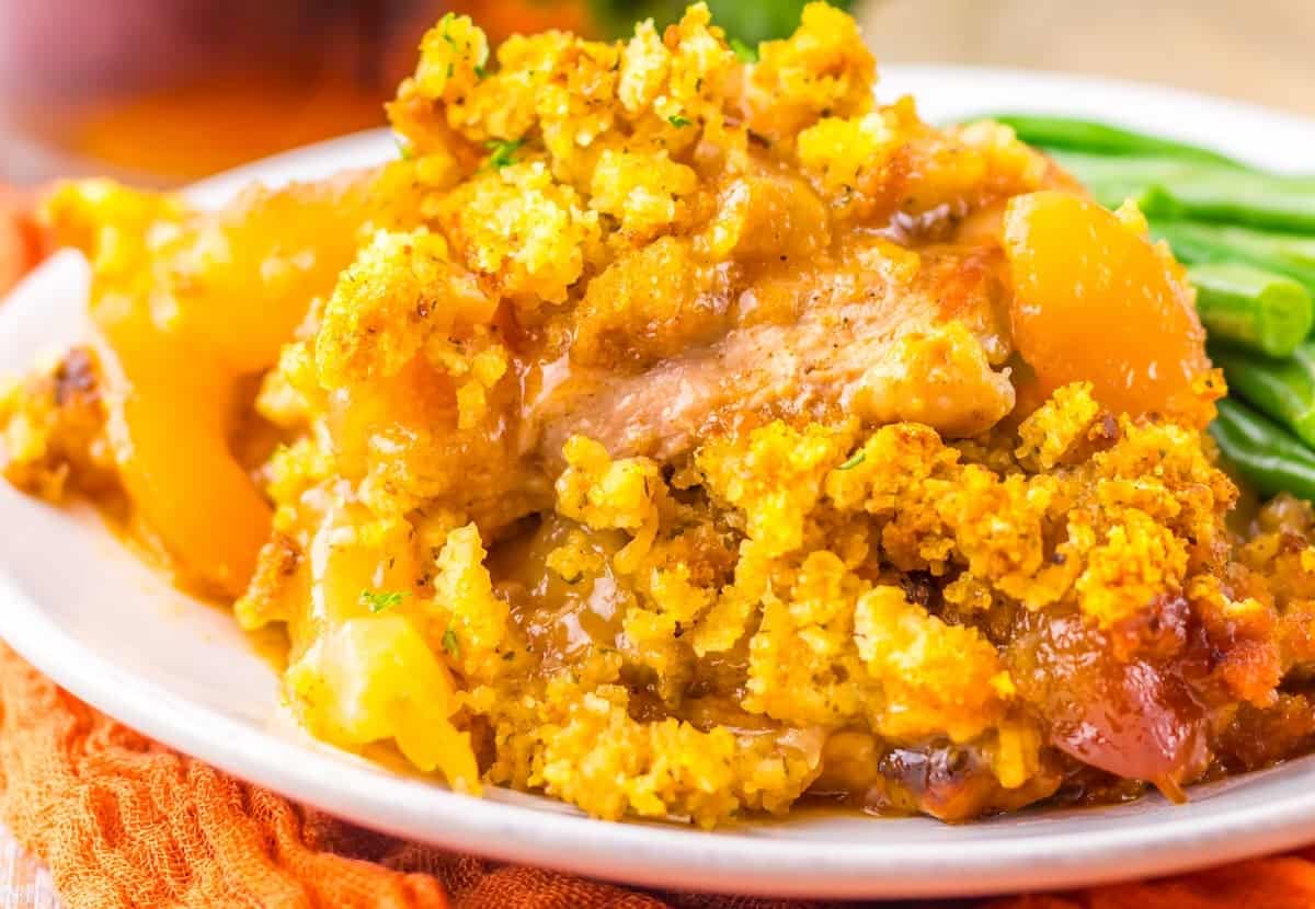 Cheesy potato casserole topped with crispy bacon and chopped green onions in a black dish.