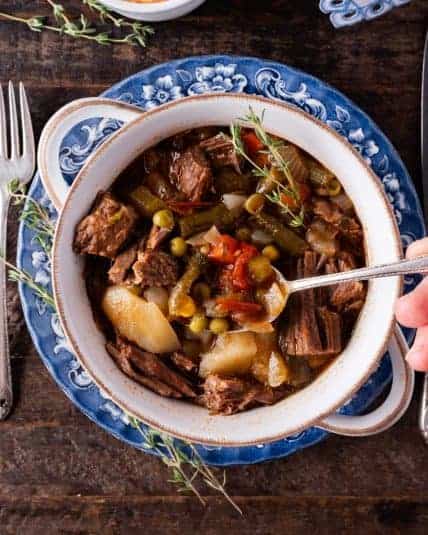 A spoon in a bowl of vegetable soup.