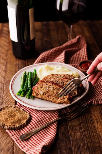 Fork cutting into slice of elk meatloaf.