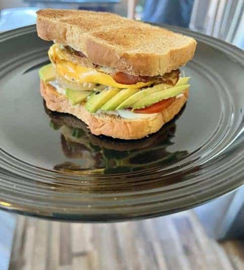Ultimate breakfast sandwich on a black plate.