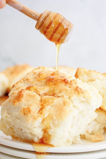 Honey being drizzled over the top of mountain dew biscuits.