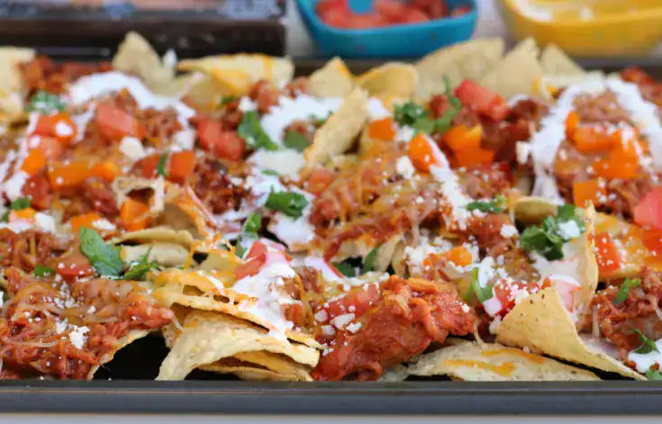Bowl of chips with salsa and a football on a jersey.