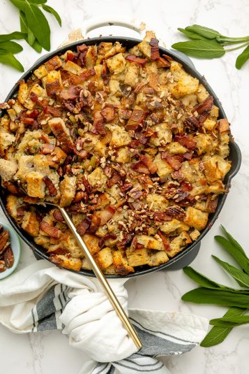 Sourdough stuffing served in a cast iron skillet, with sage leaves to garnish.