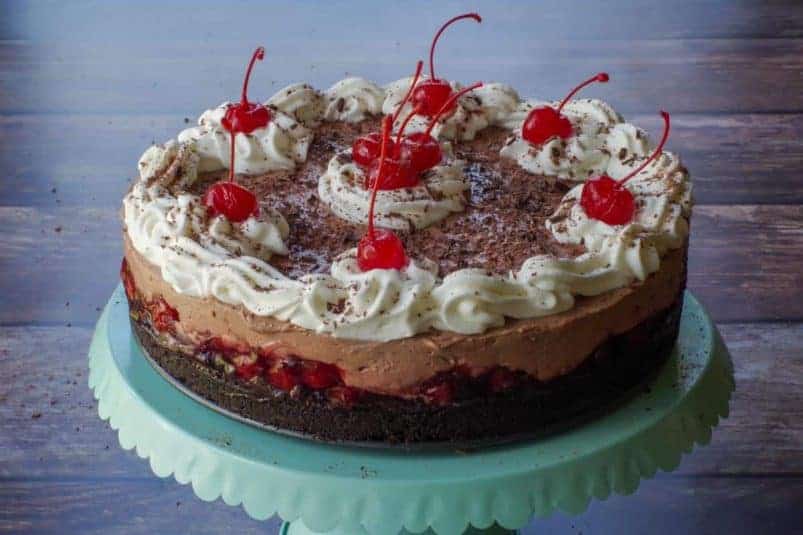 No Bake Black Forest Cheesecake on a turquoise cake stand.
