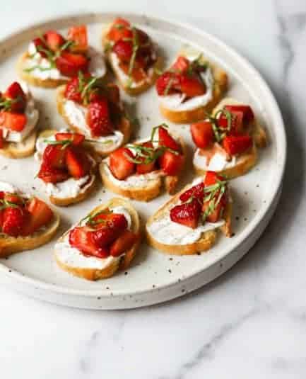 Strawberry basil bruschetta on a white plate.