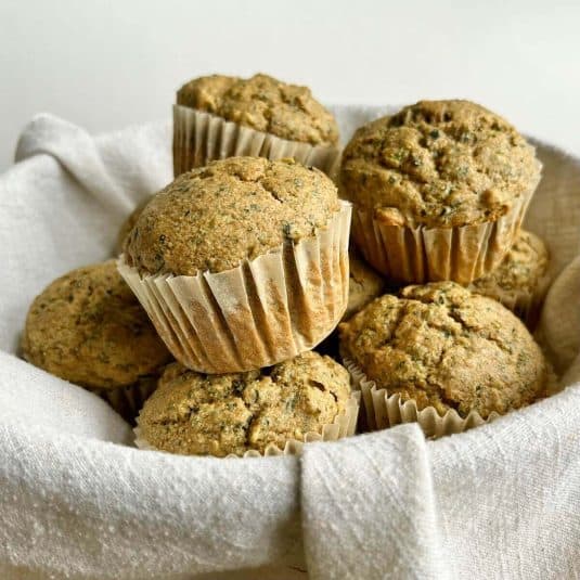 Muffins in a basket lined with a linen napkin.